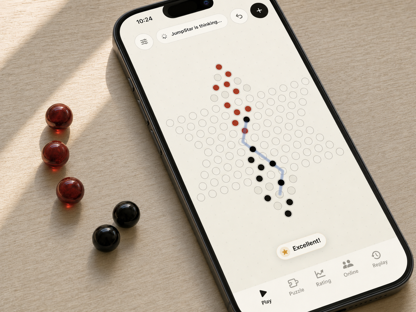 JumpStar Chinese Checkers running on iPhone beside red and black glass game pieces